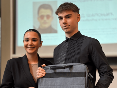 Student smera Logistika prima nagradu za izvrsnost od predstavnice kompanije Transfera, uz uručenje ranca/laptop torbe, u prostoriji Saobraćajnog fakulteta.